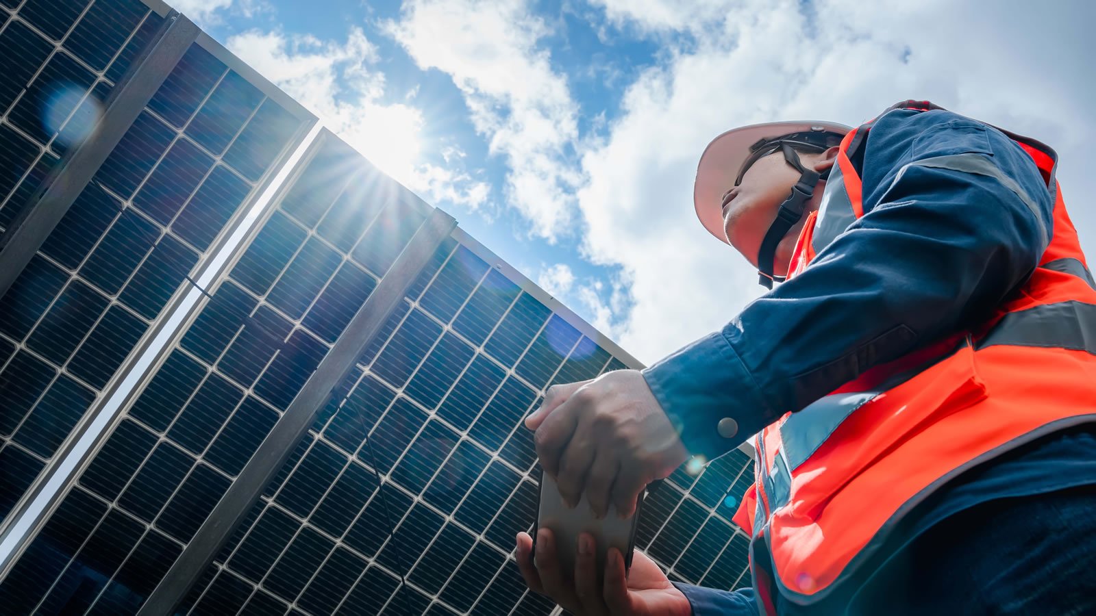 Low angle view of solar farm (solar panel) with engineer checking the operation of the system