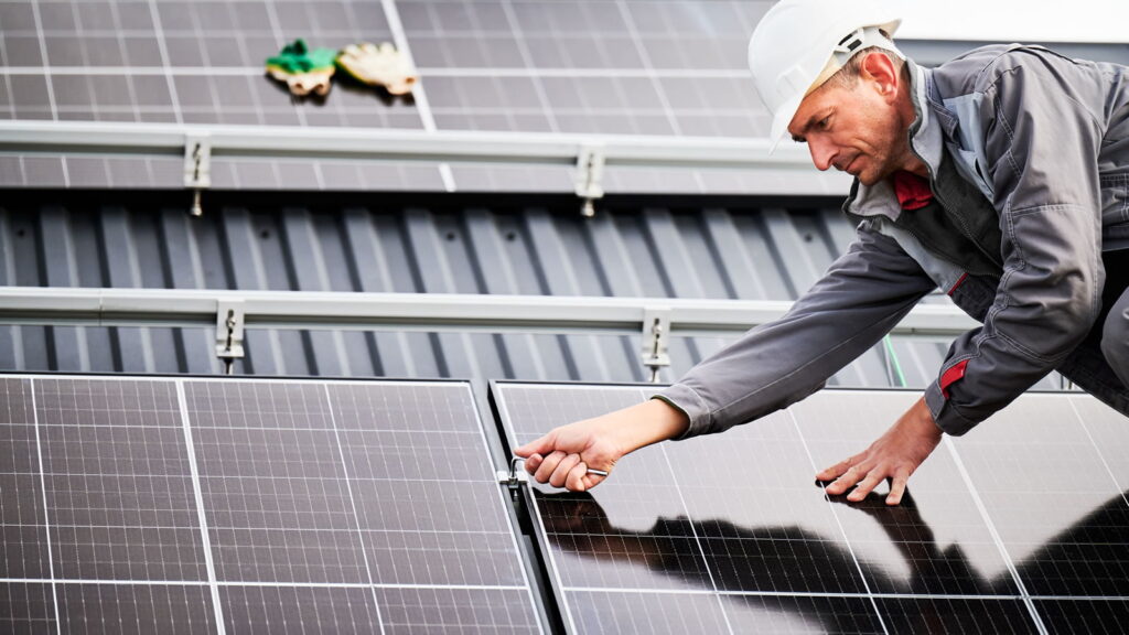 Solar engineer fixing solar panels to roof