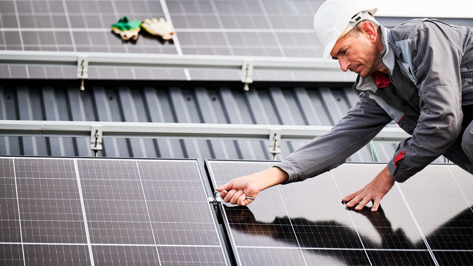 Solar engineer fixing solar panels to roof